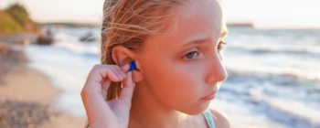 Junges Mädchen trägt Gehörschutz im Wasser